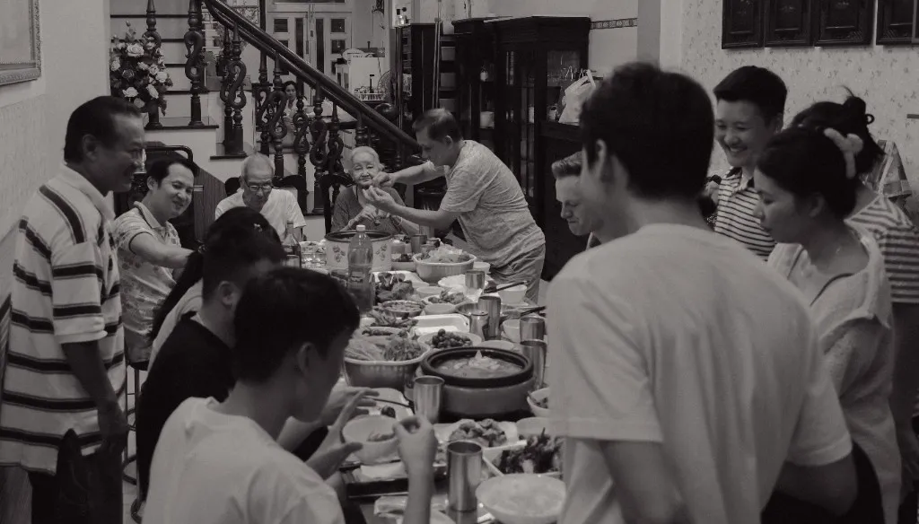 The farewell dinner — relatives crowded along one long table, dishes down the middle, grandmother among them.